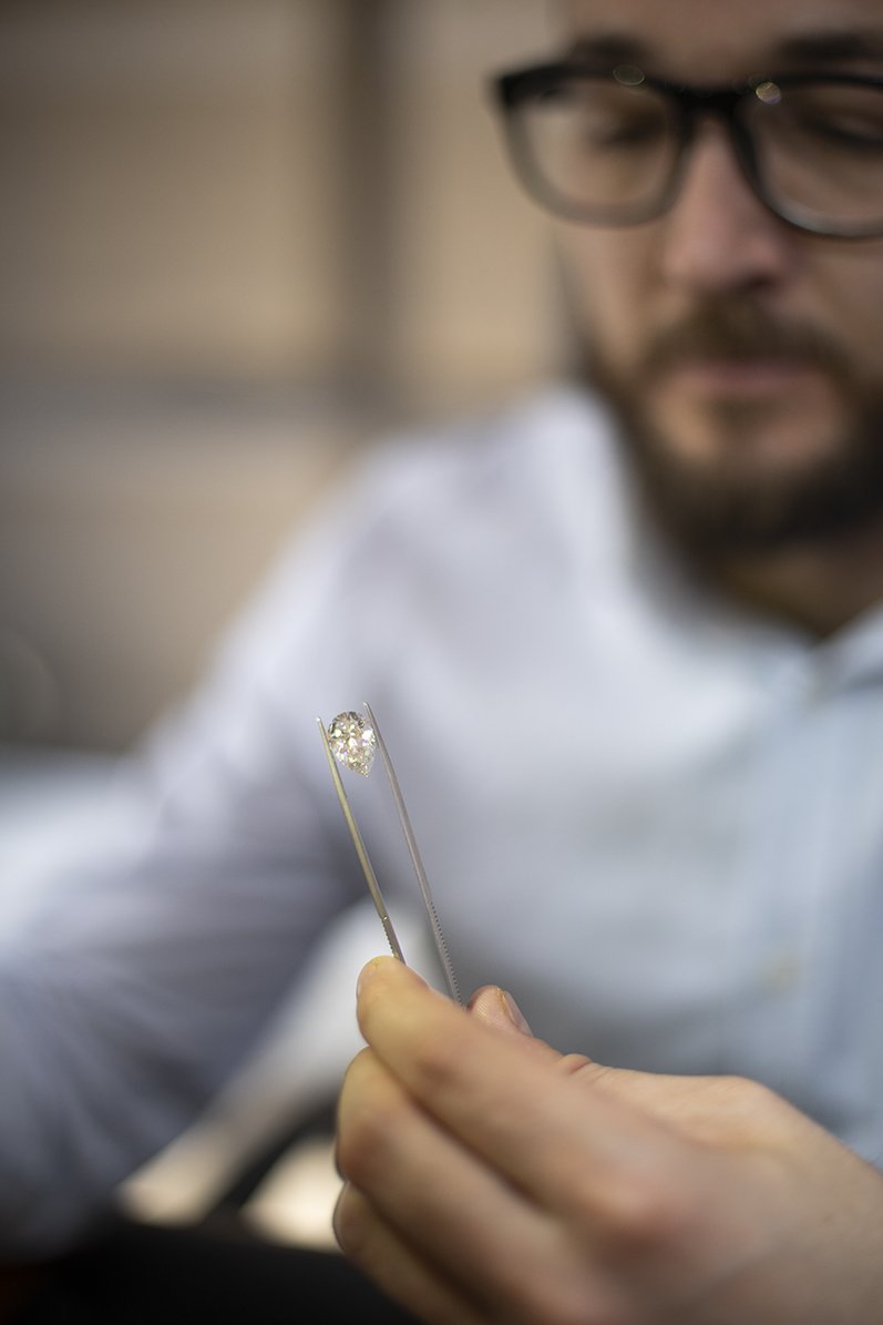A Choice Diamonds specialist examining a diamond with tweezers