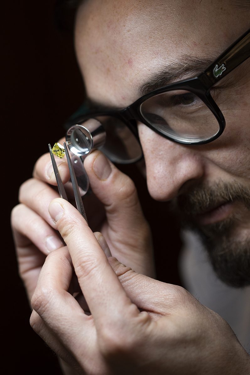 A jeweler at Choice Diamonds inspecting a fancy yellow diamond