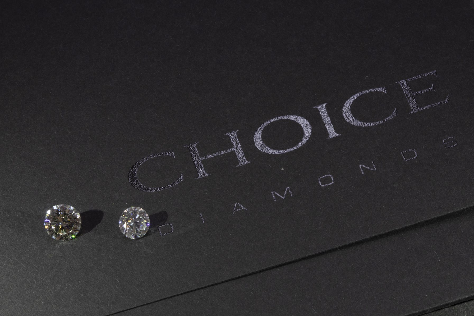 Close-up of the Choice Diamonds logo beside two polished diamonds