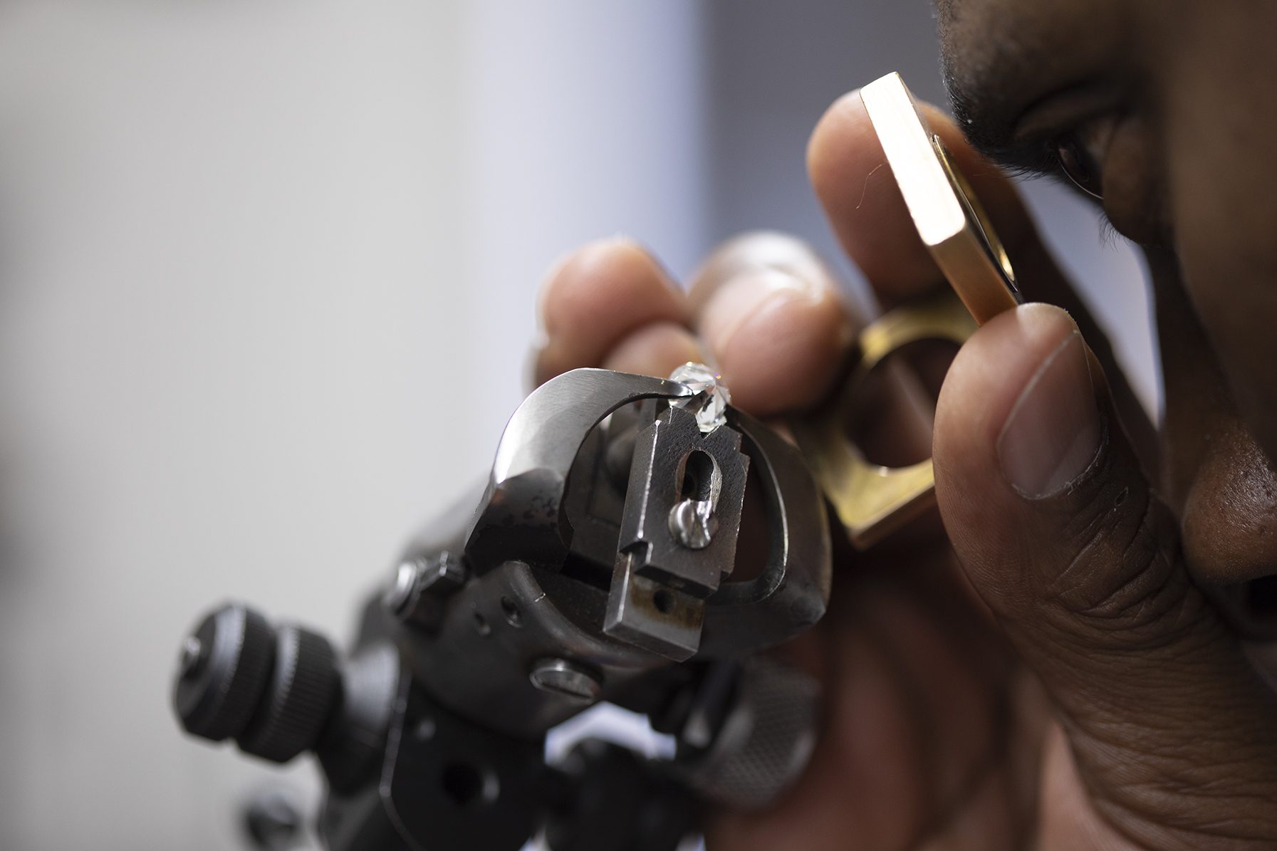 Close-up of a diamond being set into a gold mount